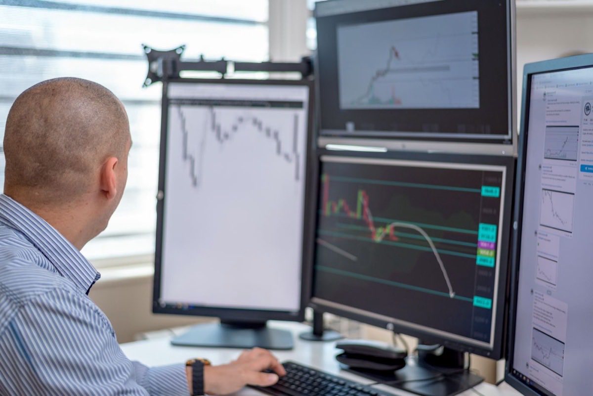 Trader working at a multi-screen commodity trading desk